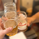 Beer held up in a toast in various glasses